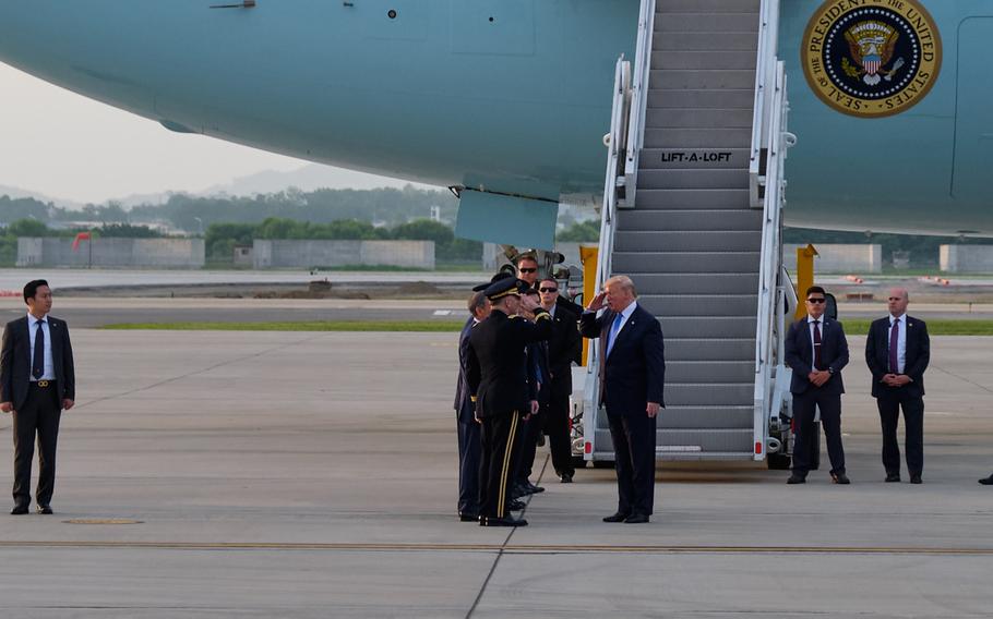 President Donald Trump and Gen. Robert Abrams, commander of U.S. Forces Korea and United Nations Command, exchange salutes at Osan Air Base, South Korea, Saturday, June 29, 2019.