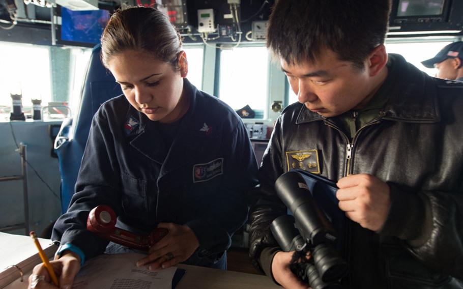 Operations Specialist 2nd Class Diana Espinoza, assigned to Destroyer Squadron 15, communicates ship movements with a South Korean navy sailor during Foal Eagle 2017. 