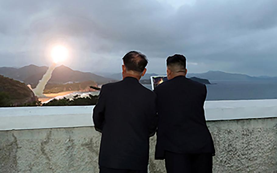North Korean leader Kim Jong Un, right, watches a missile launch in this photo released by the Korean Central News Agency on Aug. 11, 2019.
