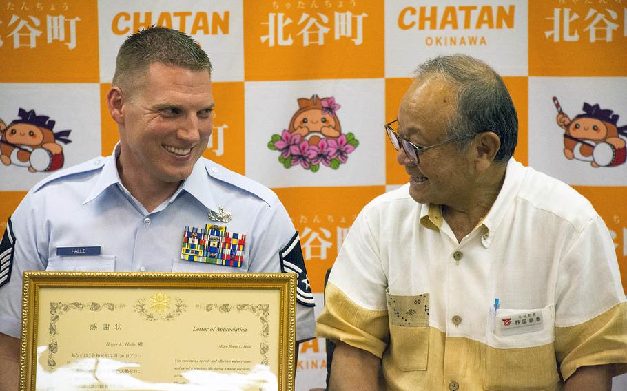 Master Sgt. Roger Halle, left, receives a letter of appreciation from Chatan Mayor Masaharu Noguni at Chatan Town Hall, Okinawa, Japan, on Monday, Aug. 19, 2019. 