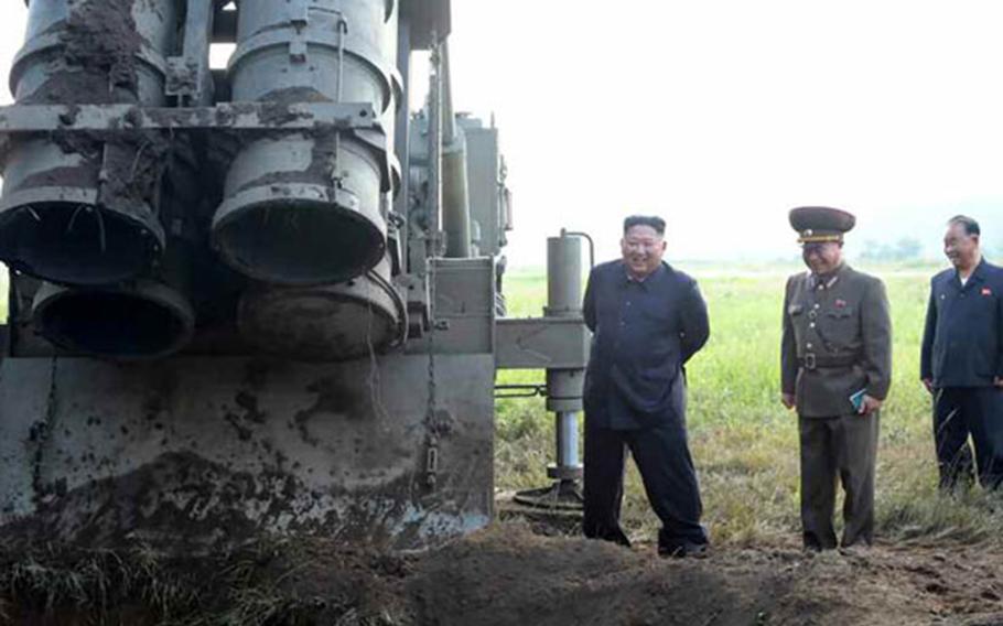 North Korean leader Kim Jong Un stands near a mobile launcher in this undated photo released by the state-run Rodong Sinmun newspaper, Wednesday, Sept. 11, 2019.