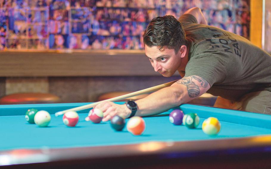 Air Force Staff Sgt. Cody Meyer shoots pool at Kelly’s Bar just outside Osan Air Base, South Korea, in June. The U.S. military has extended its curfew suspension for most U.S. forces in South Korea.