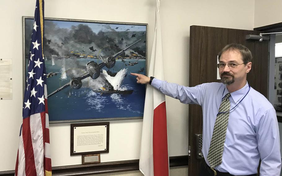 Greg Mattson, the 5th Air Force historian, shows off a painting in the unit headquarters that depicts a World War II exploit of Col. Paul Irvin "Pappy" Gunn on Sept. 11, 2019.