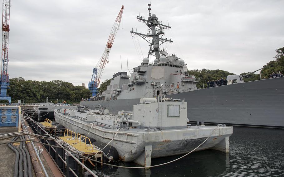 An oil-water barge sits next to the guided-missile destroyer USS John S. McCain as Yokosuka Naval Base, Japan, prepares for Typhoon Hagibis, Thursday, Oct. 10, 2019. 
