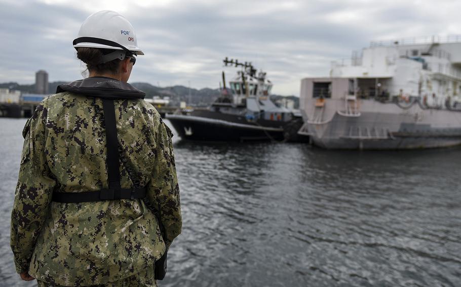 Petty Officer 2nd Class Christie Welter, a dock master at Yokosuka Naval Base, Japan, watches a harbor tug as it moves a barracks barge into dry dock ahead of typhoon, Thursday, Oct. 10, 2019. 
