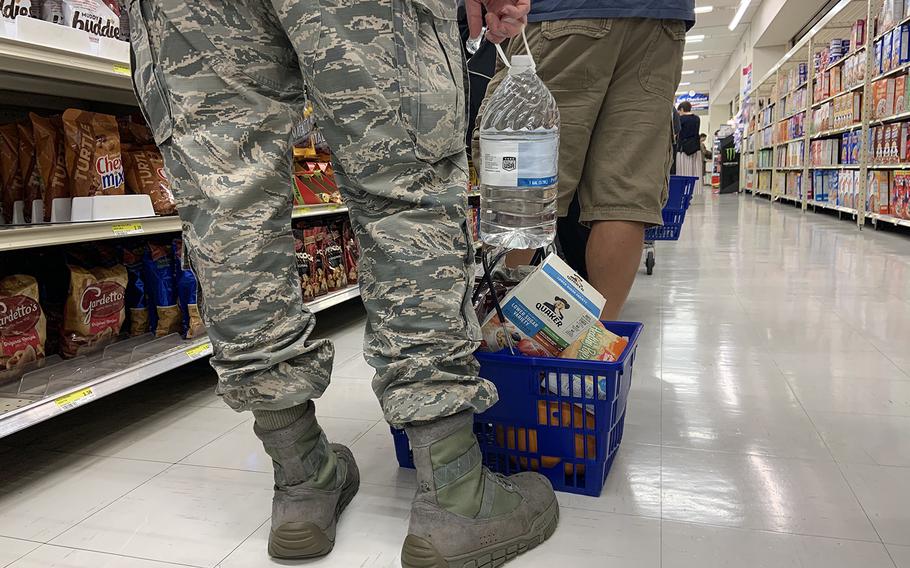 A servicemember waits at the end of a long line inside the commissary at Yokota Air Base, Japan, Friday, Oct. 11, 2019. Base residents stocked up on water, food and other supplies a day before a major typhoon was expected to hit the Tokyo area. 