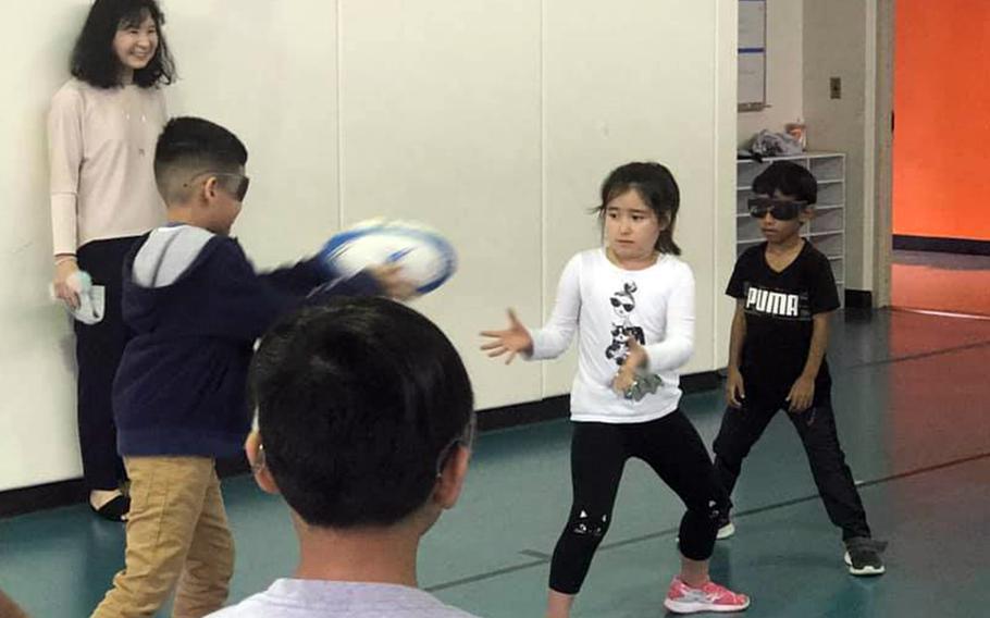 Students at Yokota West Elementary School at Yokota Air Base, Japan, tried passing and catching rugby balls while wearing glasses that simulate visual impairments, Wednesday, Oct. 16, 2019.