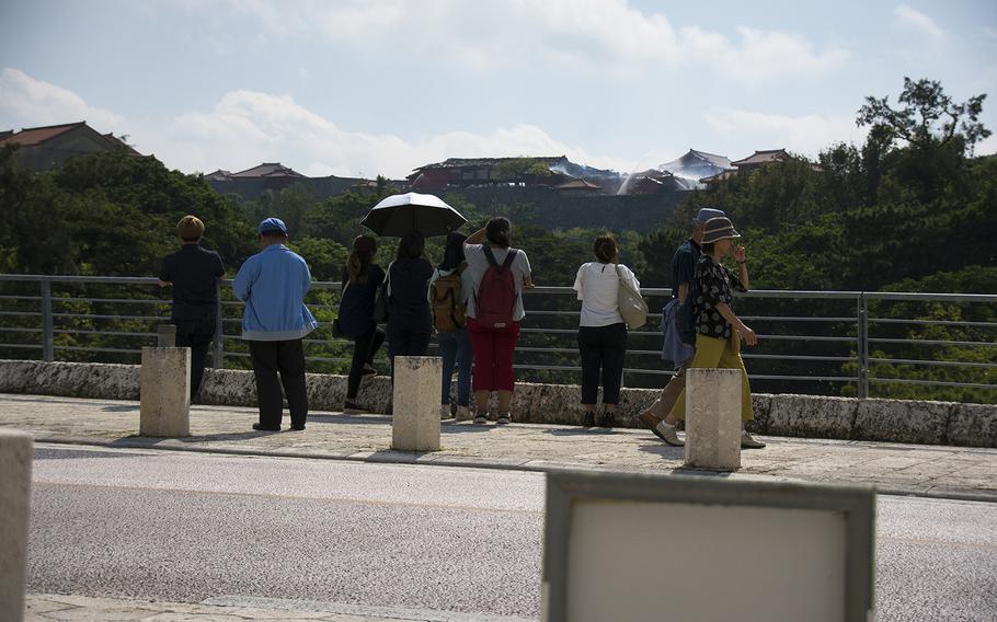 People watch as UNESCO World Heritage site Shuri Castle burns in Naha, Okinawa, Thursday, Oct. 31, 2019. 
