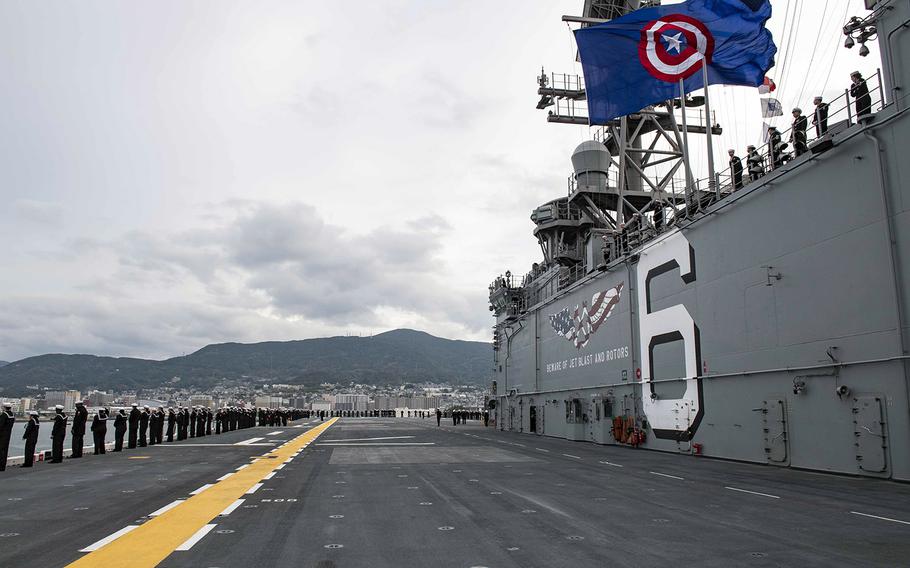 Sailors man the rails as the amphibious assault ship USS America arrives in its new homeport at Sasebo Naval Base, Japan, Friday, Dec. 6, 2019.  