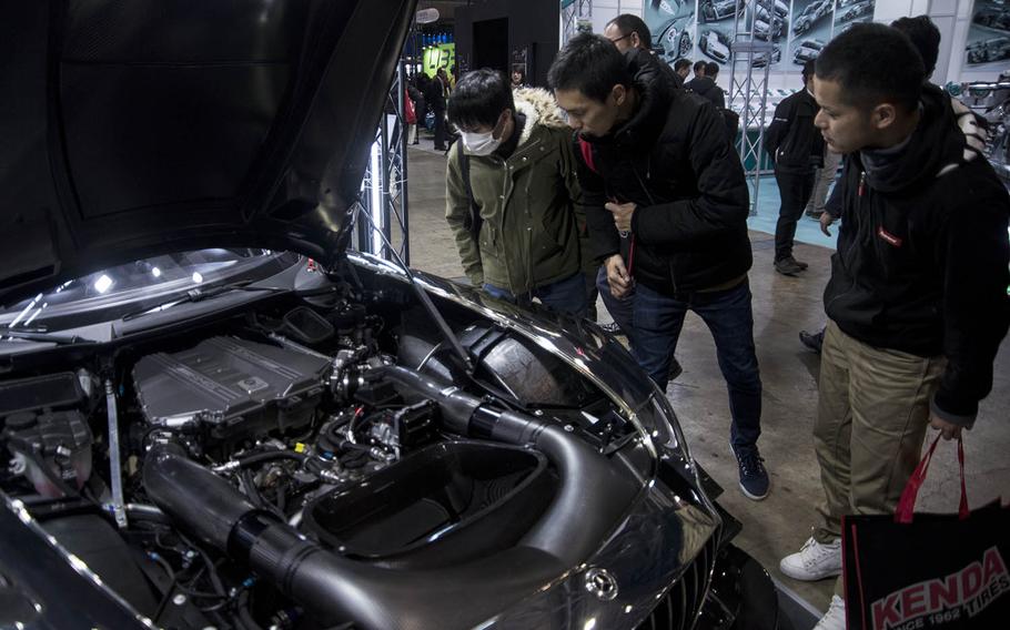 Auto enthusiasts check out the engine bay of a Mercedes sports car during Tokyo Auto Salon 2020 in Chiba, Japan, Friday, Jan. 10, 2020. 