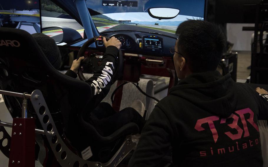 Car lovers check out a simulator during Tokyo Auto Salon 2020 in Chiba, Japan, Friday, Jan. 10, 2020. 