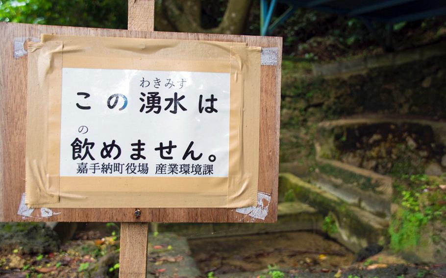 A sign posted by town officials to warn people not to drink nearby polluted spring water is pictured in Kadena, Okinawa, Friday, May 10, 2019.
