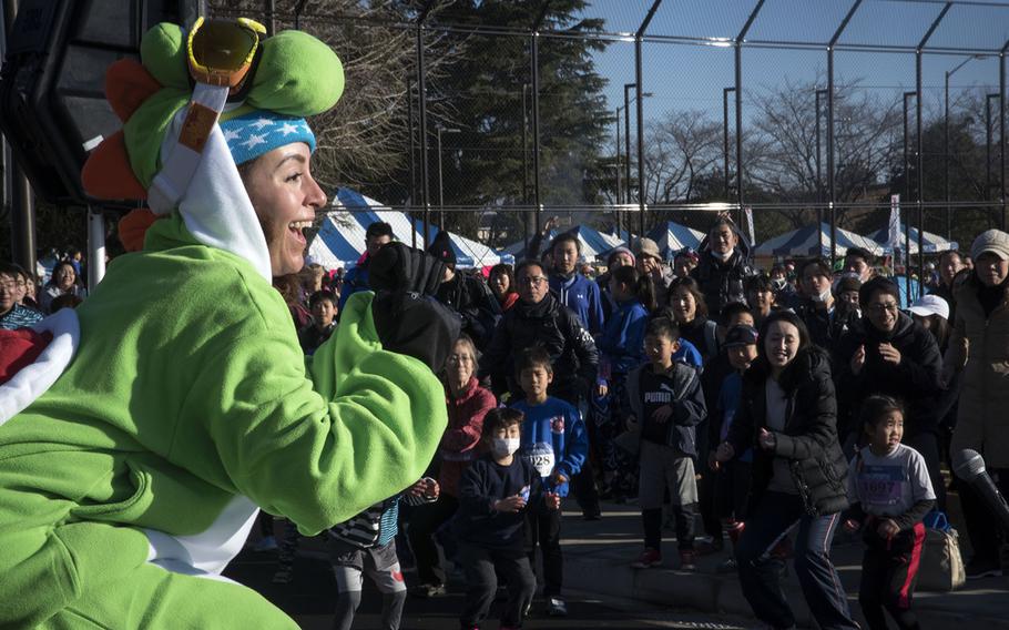 A volunteer pumps up the crowd during the 39th annual Yokota Striders Frostbite road race at Yokota Air Base, Japan, Sunday, Jan. 19, 2020. 