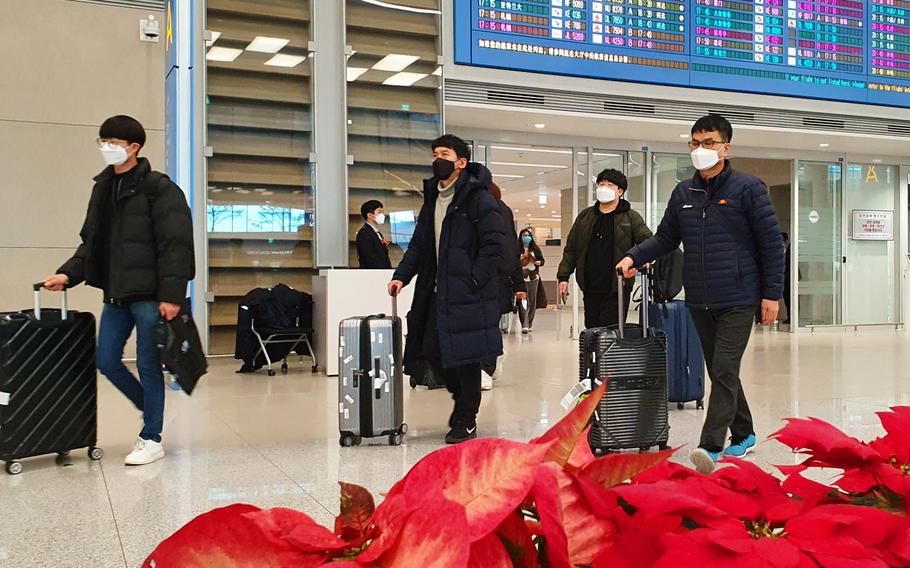 Airplane passengers exit an arrival gate wearing masks over worries of contracting the spreading Coronavirus at Incheon International Airport, South Korea, Monday, Feb. 3, 2020.