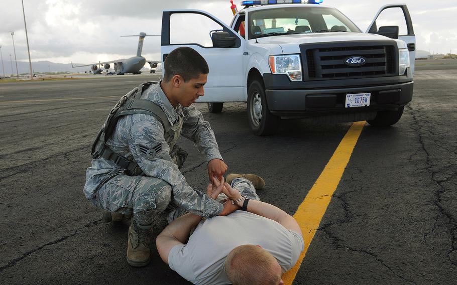 An airman with the 647th Security Forces Squadron apprehends a mock trespasser during an exercise at Joint Base Pearl Harbor-Hickam, Hawaii, March 9, 2013.