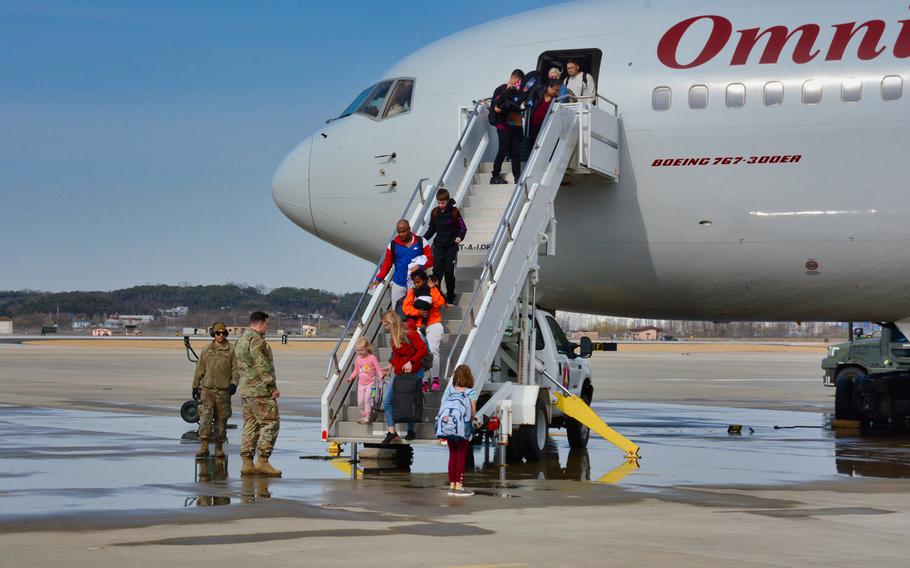 American troops and family members arrive on Osan Air Base, South Korea, on Friday, March 13, 2020, days after they were kicked off a military charter flight in Seattle amid confusion over an Army order halting moves amid the coronavirus crisis. 