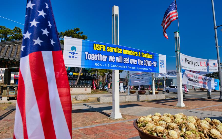 American flags wave alongside coronavirus banners outside Camp Humphreys, South Korea, Monday, March 16, 2020.