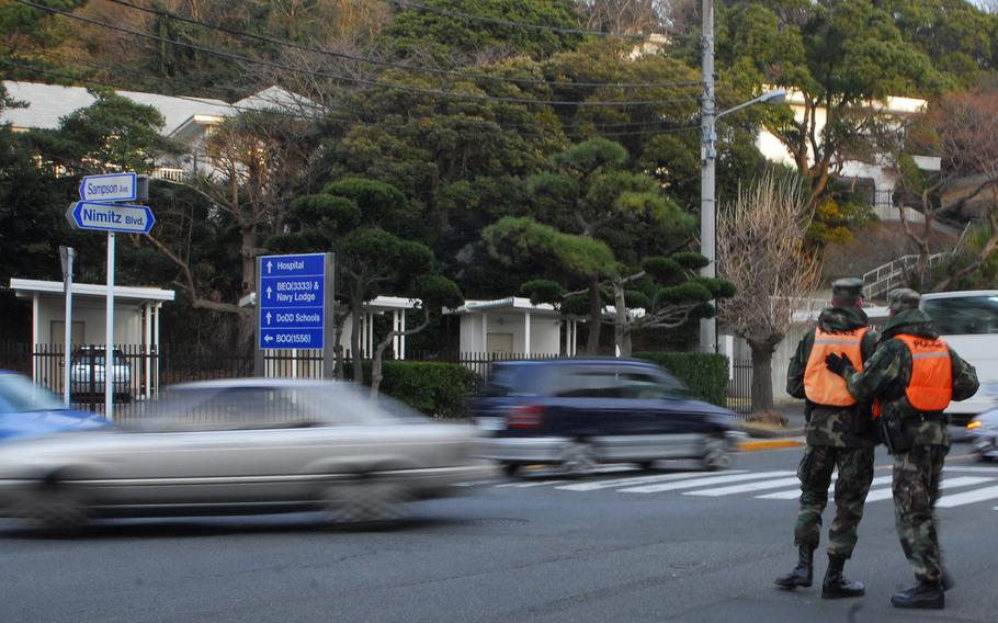 Sailors direct traffic near the Womble Gate at Yokosuka Naval Base, Japan, in 2010. 
