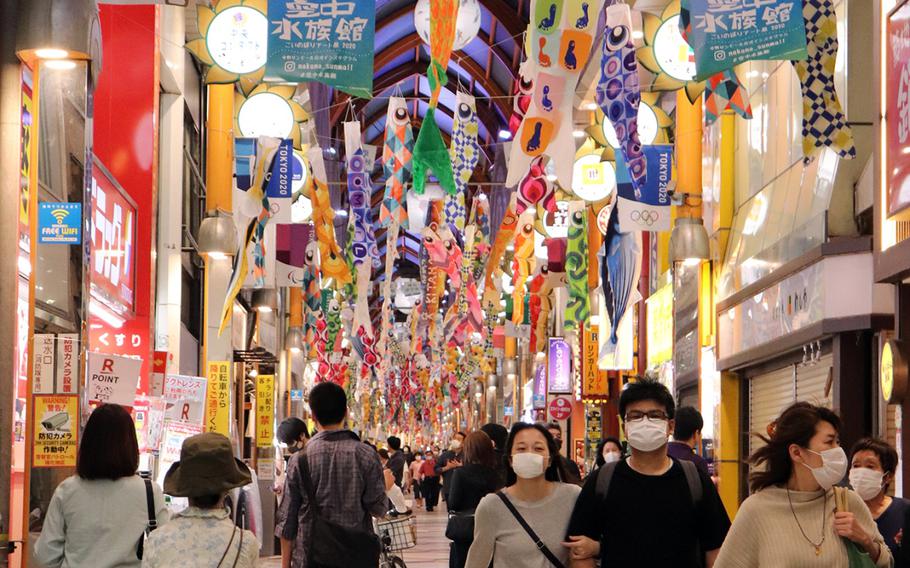 People walk through Nakano Broadway, a popular shopping area in Tokyo, Sunday, May 3, 2020. 