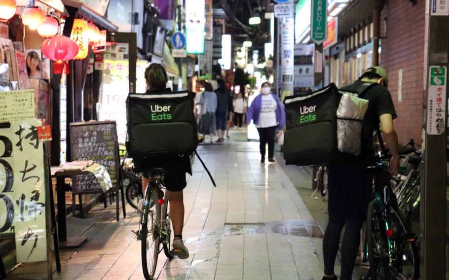 Uber Eats workers prepare to make food deliveries in the Nakano section of Tokyo, Sunday, May 3, 2020. 