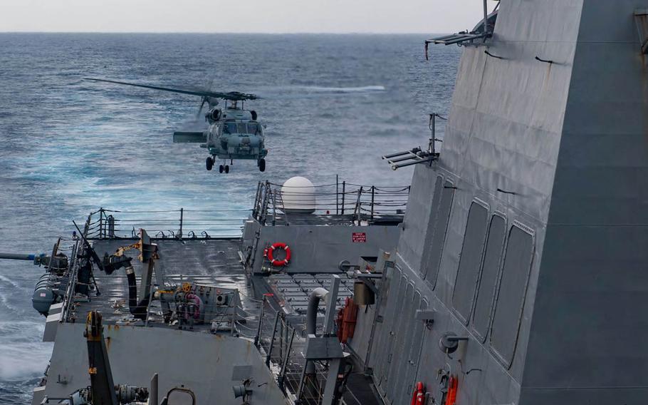 An MH-60R helicopter lands aboard the flight deck of the Arleigh Burke-class guided-missile destroyer USS Mustin on May 28, 2020. 
