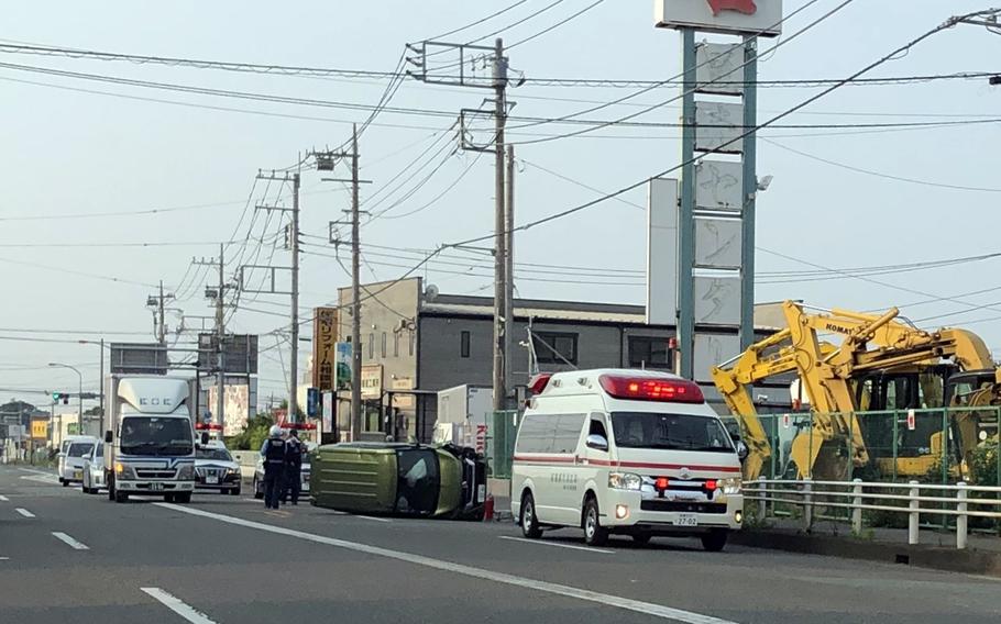 Japanese first responders tend to a local man whose vehicle toppled over in Sagamihara, Japan, Friday, June 5, 2020. 