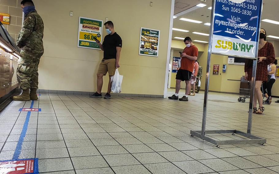 Customers stand in line inside the food court at Yokota Air Base in western Tokyo, Friday, June 12, 2020. 