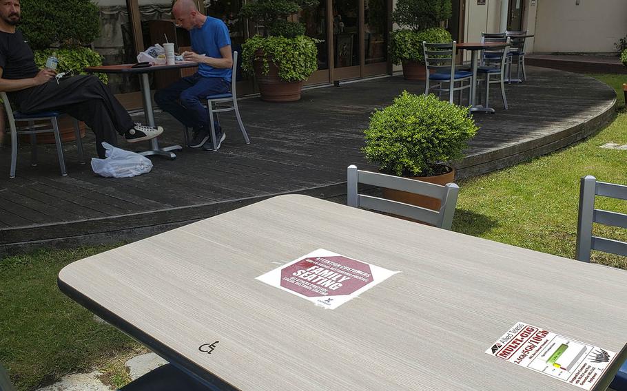 People eat lunch outside the Yokota Community Center at Yokota Air Base, Japan, Friday, June 12, 2020. U.S. Forces Japan on lowered its health protection condition from Charlie to Bravo that day. 