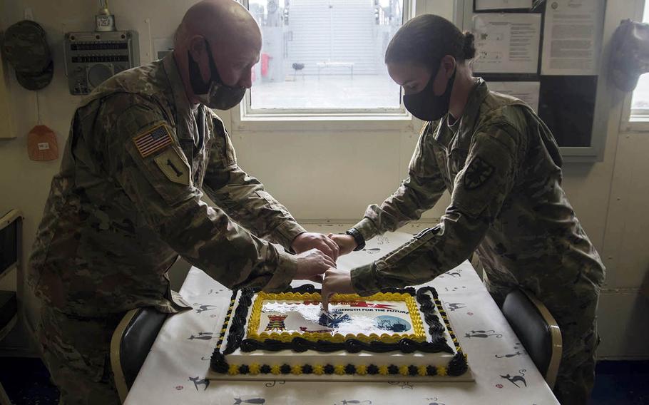 Sgt. 1st Class Vincent Passero, 49, and Pvt. Courtney Pearson, 19, cut a cake in celebration of the Army's 245th birthday aboard the Army Vessel Harpers Ferry at Yokohama North Dock, Japan, Sunday, June 14, 2020.