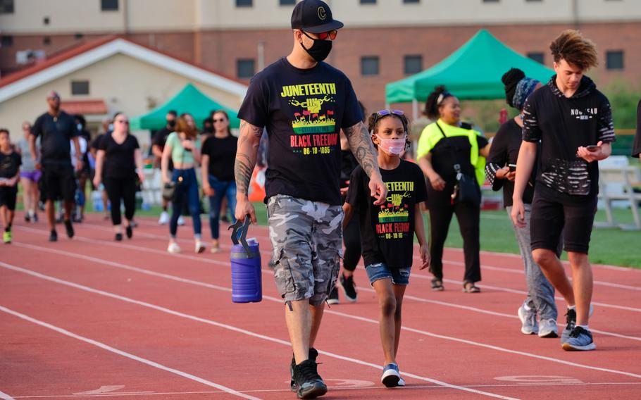 People walk the track at Balboni Field for 1,865 seconds, representing the year 1865, during the inaugural Juneteenth celebration at Camp Humphreys, South Korea, Friday, June 19, 2020.
