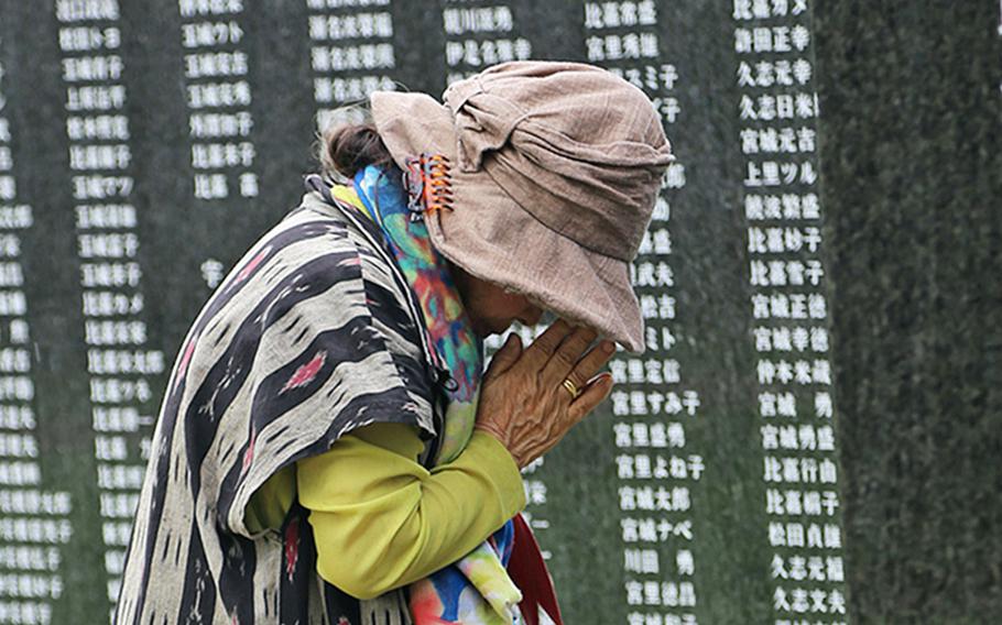 A woman prays for loved ones lost in the Battle of Okinawa during the annual Irei no Hi ceremony at Peace Memorial Park in Okinawa, Japan, June 23, 2019. This year's ceremony was scaled down because of coronavirus concerns.