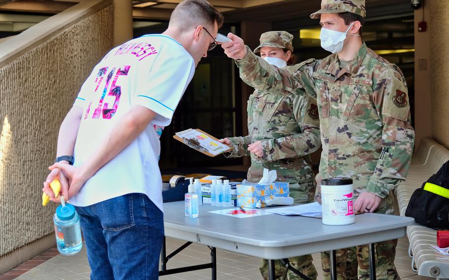 An airman is screened for coronavirus symptoms by 51st Fighter Wing medical staff before he enters Osan Air Base, South Korea, April 3, 2020.