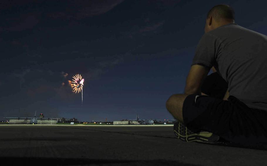 Fireworks explode behind C-130J Super Hercules aircraft at Yokota Air Base, Japan, Thursday, July 2, 2020.