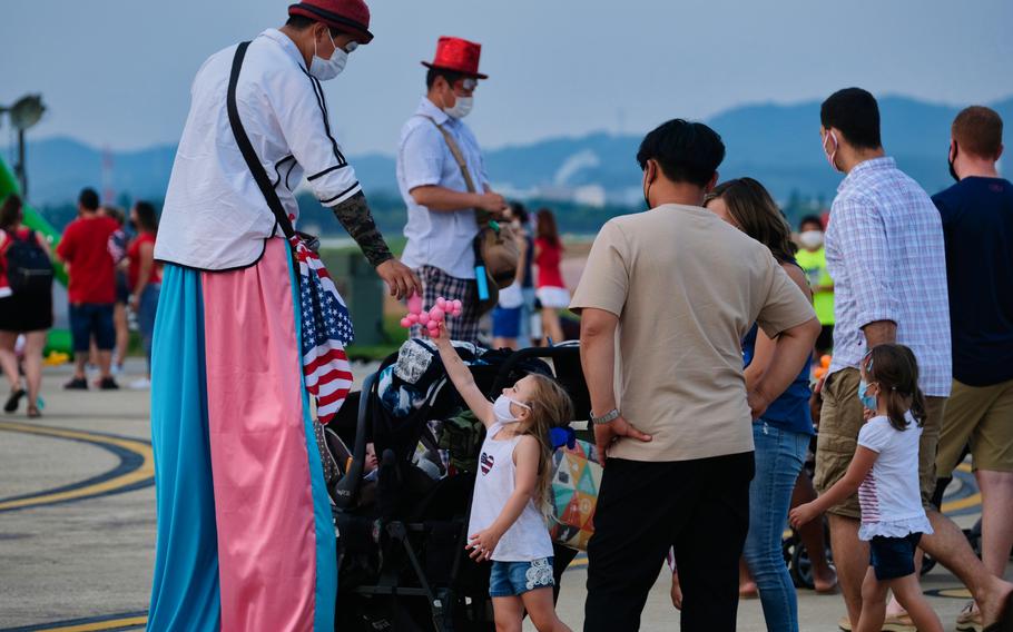 A balloon artist gives a balloon shaped like a dog to a young girl at Liberty Fest 2020 on Osan Air Base, South Korea, Saturday, July 4, 2020.



