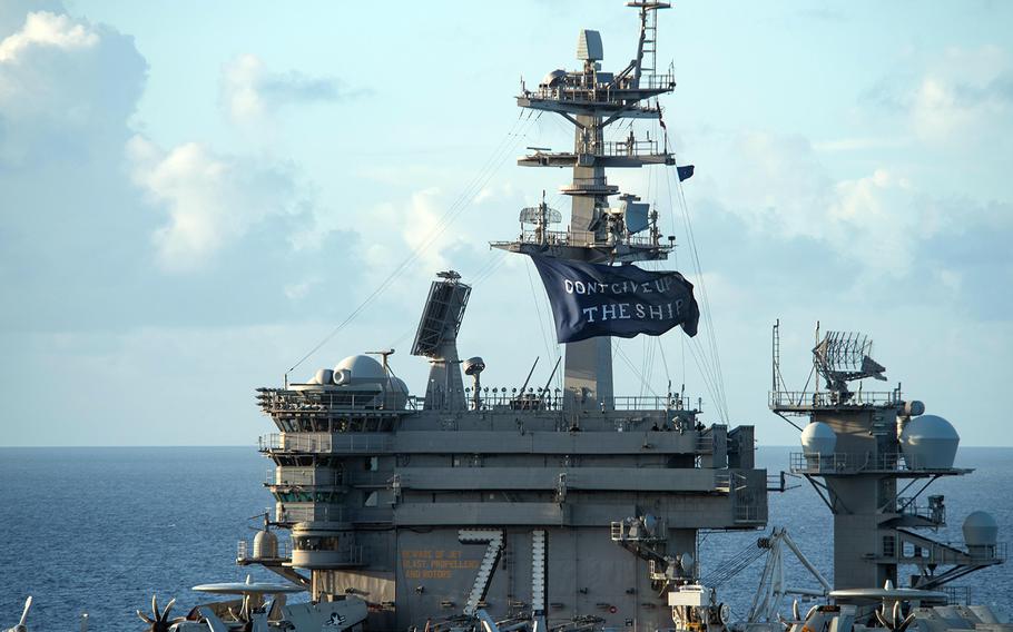 The aircraft carrier USS Theodore Roosevelt flies a "Don't Give Up the Ship" flag in the Philippine Sea, June 3, 2020. 