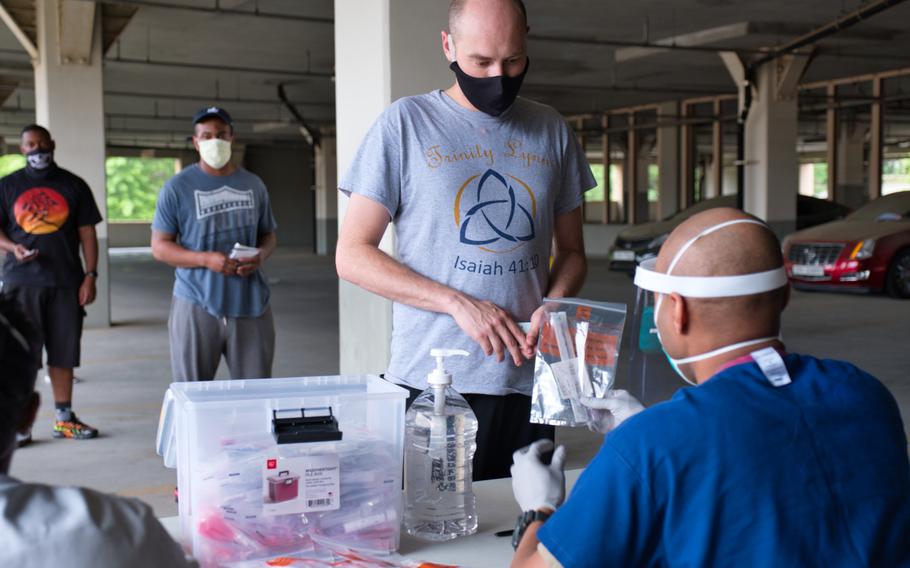 A service member receives a coronavirus test kit within hours of arriving at Osan Air Base, South Korea, Tuesday, July 14, 2020.
