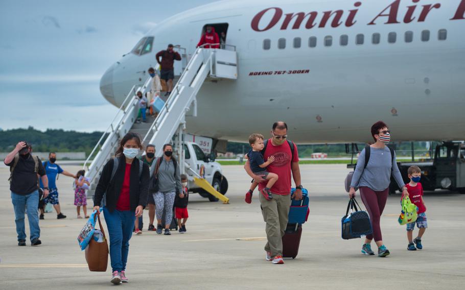 Service members and families exit the Patriot Express after arriving at Osan Air Base, South Korea, Tuesday, July 14, 2020.