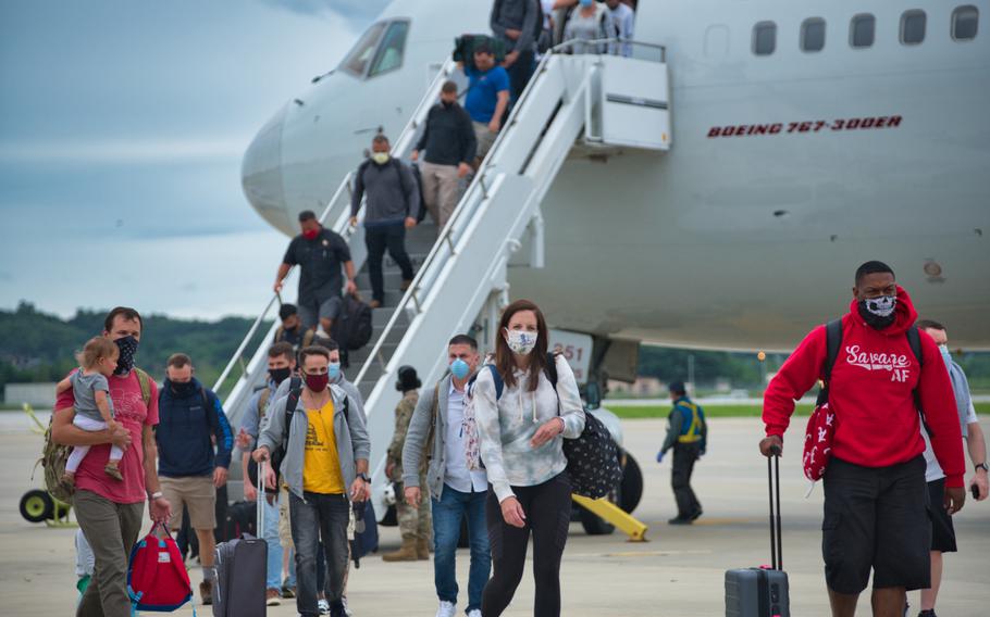 Service members and families exit the Patriot Express after arriving at Osan Air Base, South Korea, Tuesday, July 14, 2020