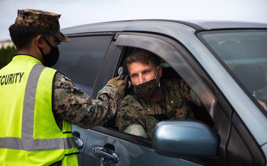 A Marine conducts a temperature check during a coronavirus screening at Camp Courtney, Okinawa, July 13, 2020. 