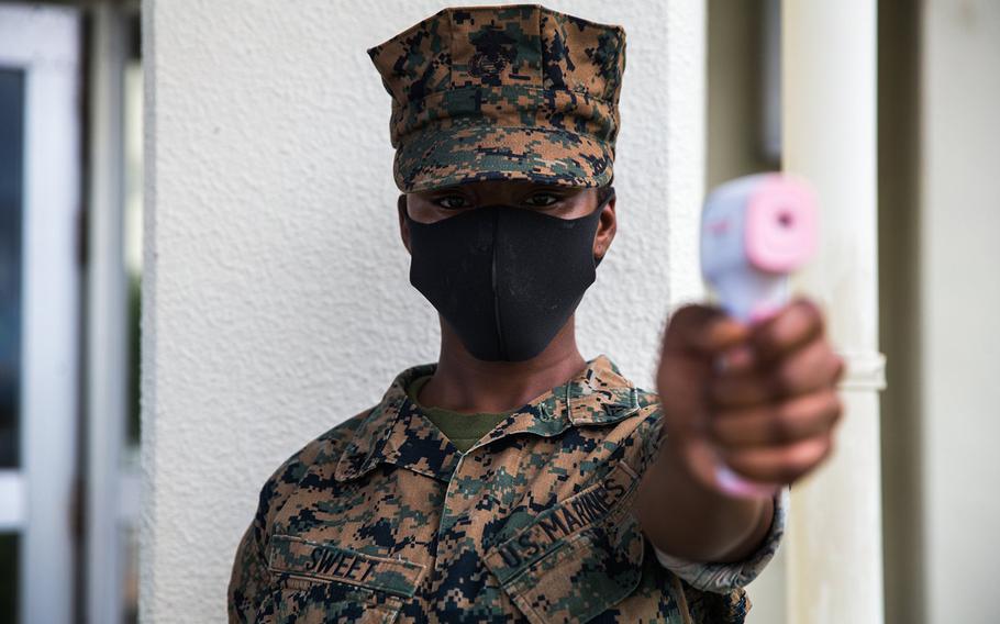 A Marine from Headquarters Battalion, 3rd Marine Division conducts a temperature check at Camp Courtney, Okinawa, July 13, 2020.