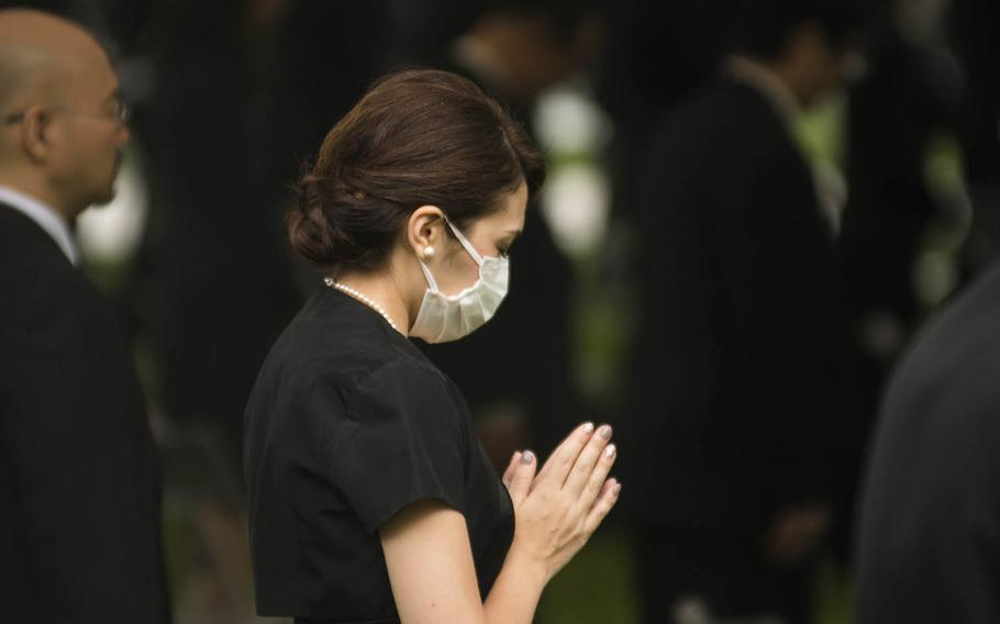 A woman prays at Hiroshima Peace Memorial Park, Thursday, Aug. 6, 2020, during a ceremony marking the 75th anniversary of the atomic bombing. 