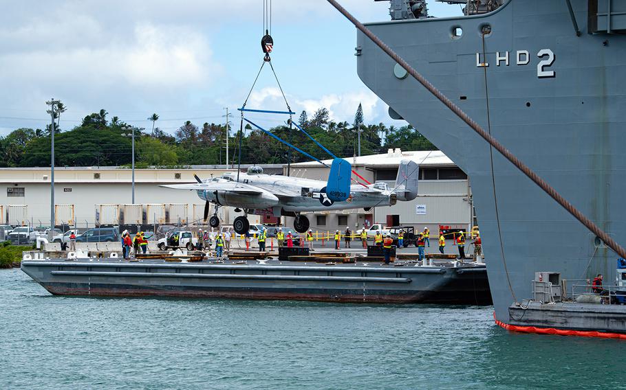 A World War II-era B-25 Mitchell bomber is lowered onto a dock at Joint Base Pearl Harbor-Hickam, Hawaii, Aug. 11, 2020.