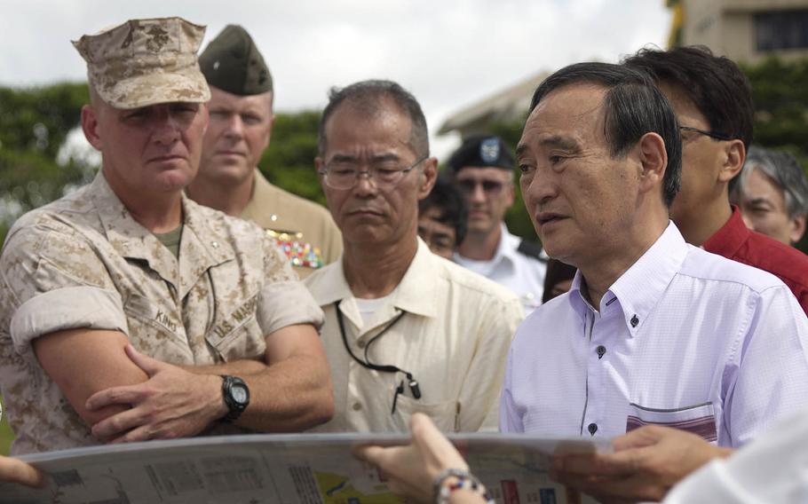 Then-Japanese Chief Cabinet Secretary Yoshihide Suga, right, visits Camp Kinser, Okinawa, Aug. 12, 2015. Suga became his country's 99th prime minister, Wednesday, Sept. 17, 2020.