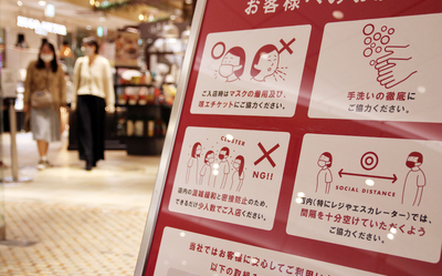 A sign at a shopping area in central Tokyo reminds patrons to wear a mask, wash their hands and follow other anti-coronavirus measures, Tuesday, Nov. 17, 2020. 