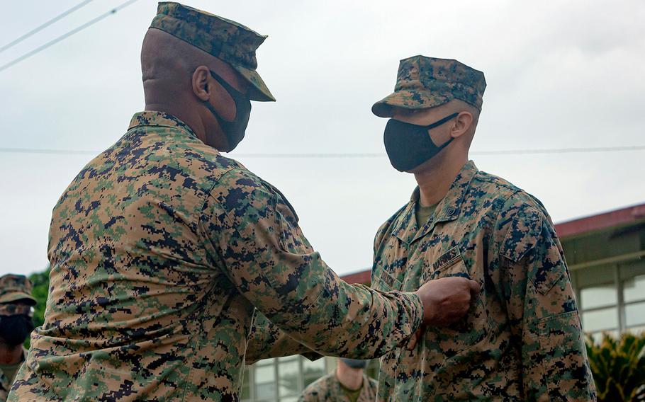 Staff Sgt. Billy Dixson, right, receives the Navy and Marine Corps Commendation Medal from Marine Corps Air Station Futenma commander Col. Henry Dolberry Jr., Nov. 13, 2020. Dixson was honored for saving a Japanese woman from drowning last month. 