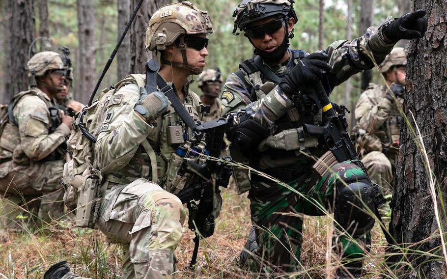 Capt. Kris Candelaria, a team leader from 2nd Battalion, 5th Security Force Assistance Brigade, and 1st Lt. Wilhelmus Raditya of Indonesia discuss plans for approaching an objective during a live-fire exercise at the Joint Readiness Training Center at Fort Polk, La., on Oct. 27, 2020.