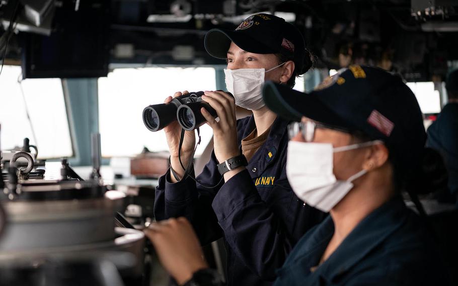Ensign Antonia Vinci scans the horizon from the bridge of the USS Barry as the the guided-missile destroyer sails through the Taiwan Strait, Nov. 20, 2020.