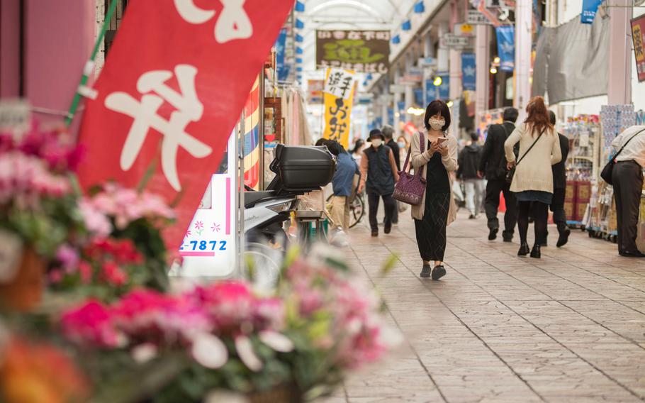 People wear masks while visiting the Yokohamabashi shopping district in Yokohama, Japan, Nov. 20, 2020. 