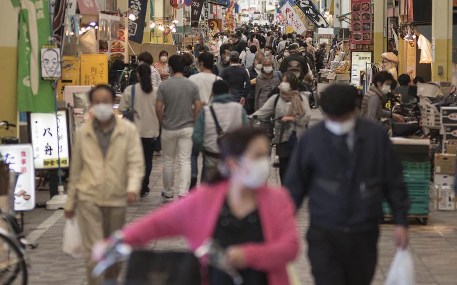 People wear masks while visiting the Yokohamabashi shopping district in Yokohama, Japan, Nov. 20, 2020.