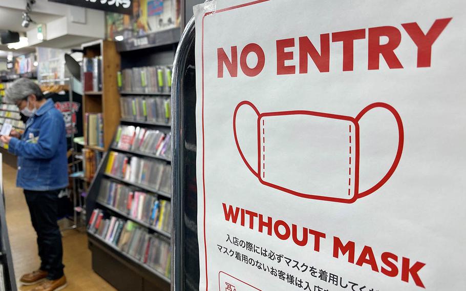 A sign outside a western Tokyo record store warns patrons not to enter without a mask, Sunday, Nov. 22, 2020.